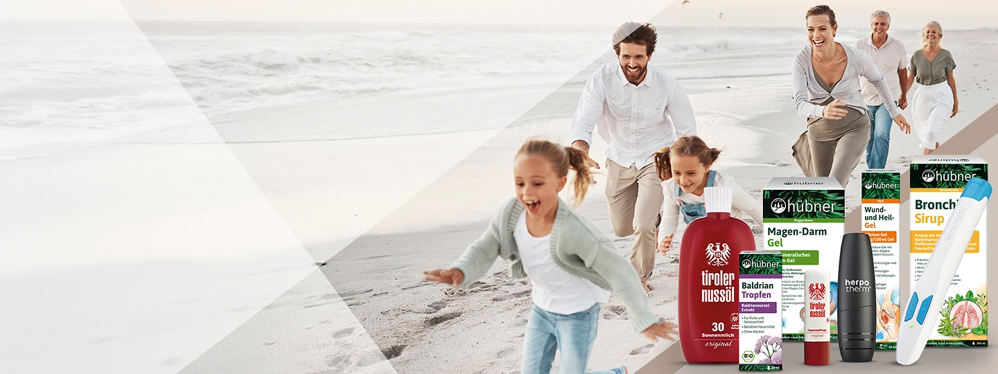 Eine Glückliche Familie läuft über einen Strand im Urlaub. Zusätzlich sind Produktempfehlungen für die Reiseapotheke gezeigt.