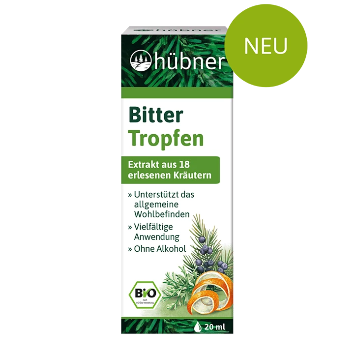 Schachtel mit Kräuterextrakt Hübner Bitter Tropfen mit Bildern der Inhaltsstoffe und grünem Etikett, auf dem steht, dass das Produkt neu, biologisch und alkoholfrei ist.