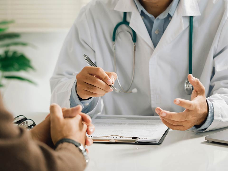 Ein Patient sitzt bei einem Arzt und lässt sich beraten.